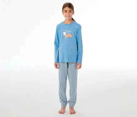 Fille souriante portant un pyjama. Le haut bleu clair à manches longues est imprimé d'un verre de lait, d'un croissant et du mot "Bonjour". Le pantalon est rayé bleu clair et blanc.