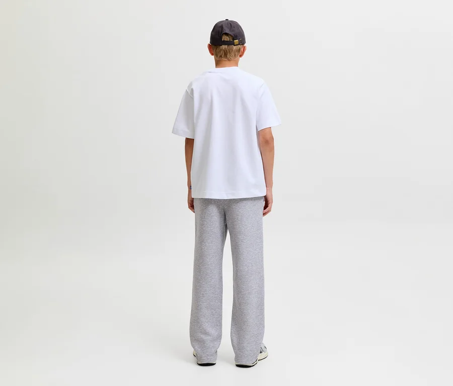 Personne de dos, portant un t-shirt blanc, une casquette foncée et un pantalon de survêtement gris Jack&Jones Bradley.
