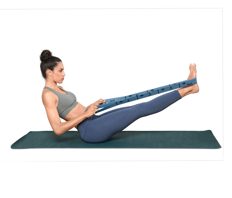 Femme faisant de l'exercice avec une sangle élastique de fitness sur un tapis.