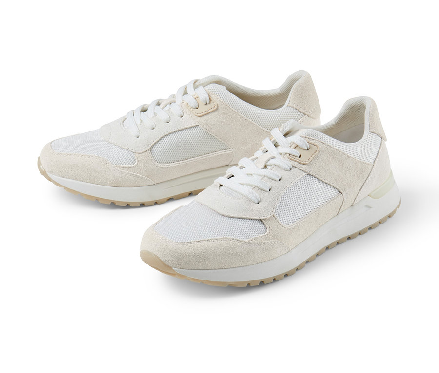 Deux baskets en cuir velours crème sont posées sur un fond blanc.