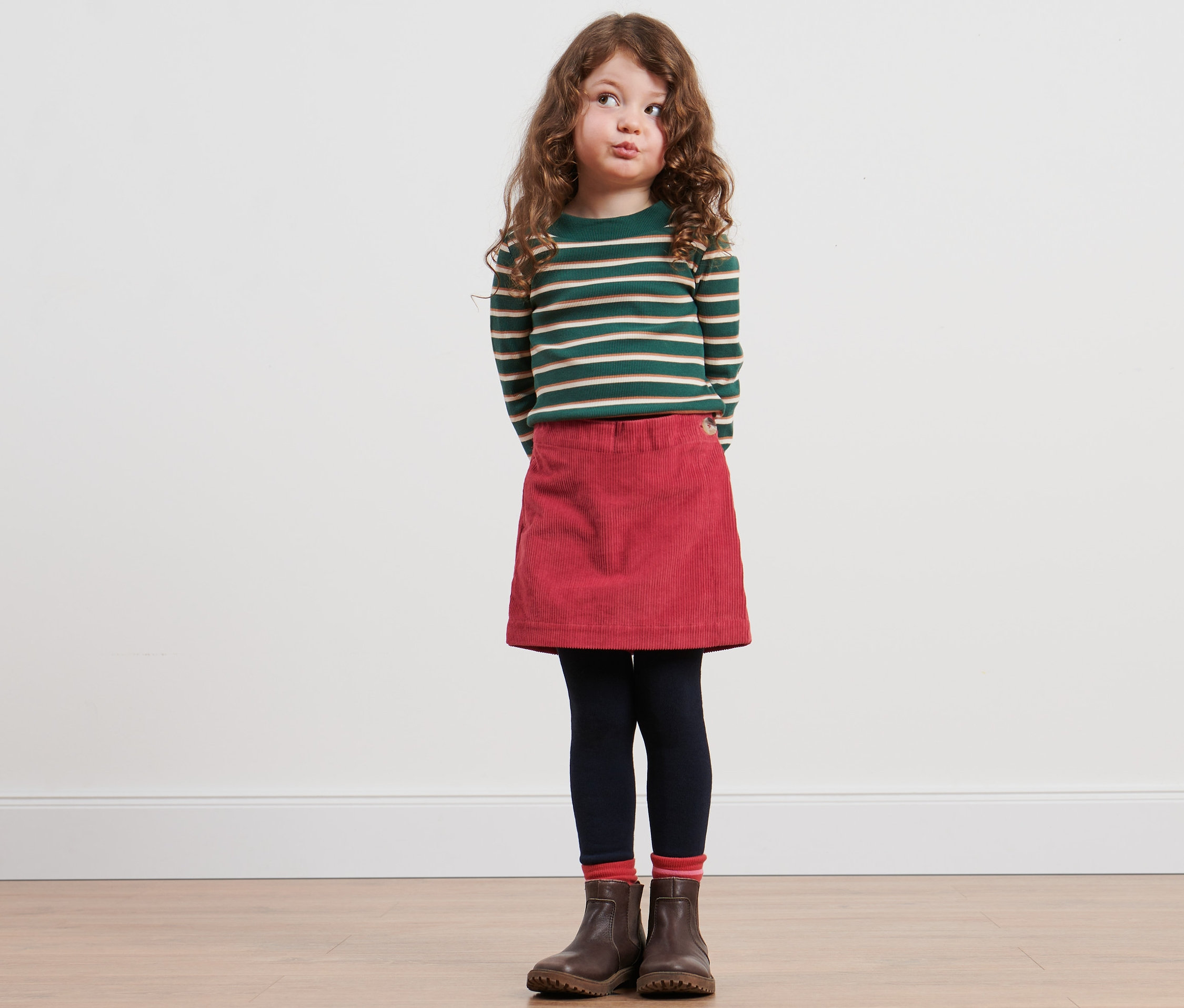 Fillette portant un haut rayé et une jupe-culotte portefeuille.