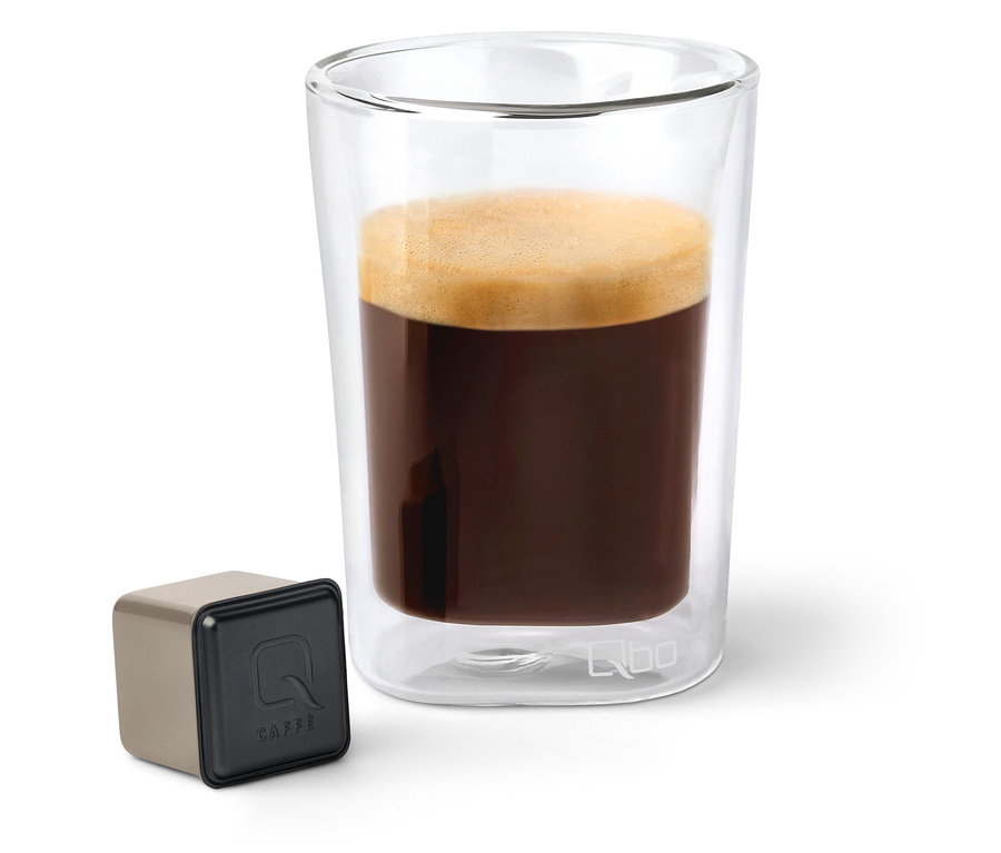 Café dans un verre transparent à côté d'une capsule Qbo Caffè.