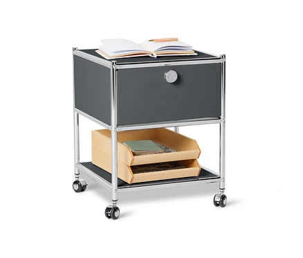 Table d'appoint grise en métal avec tiroir « CN3 ». Un carnet ouvert et un stylo sont posés sur le dessus.