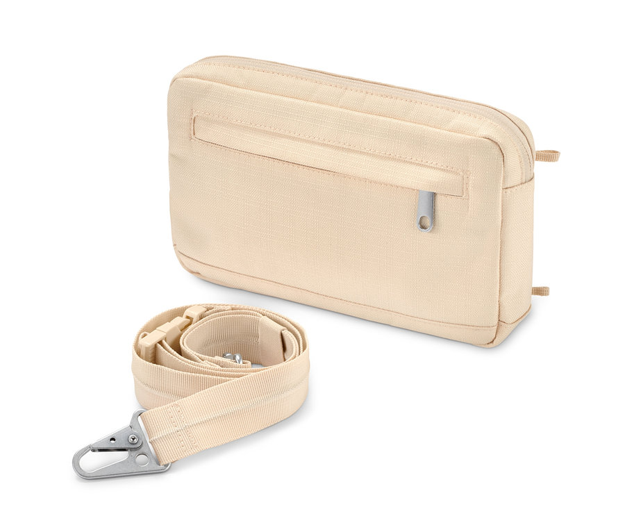 Un sac à bandoulière avec ceinture de sécurité beige et une sangle enroulée sont posés l'un à côté de l'autre.