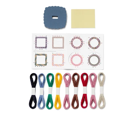 Kit de bricolage « bracelets brésiliens » avec des fils de coton colorés, autocollants et un gabarit bleu.