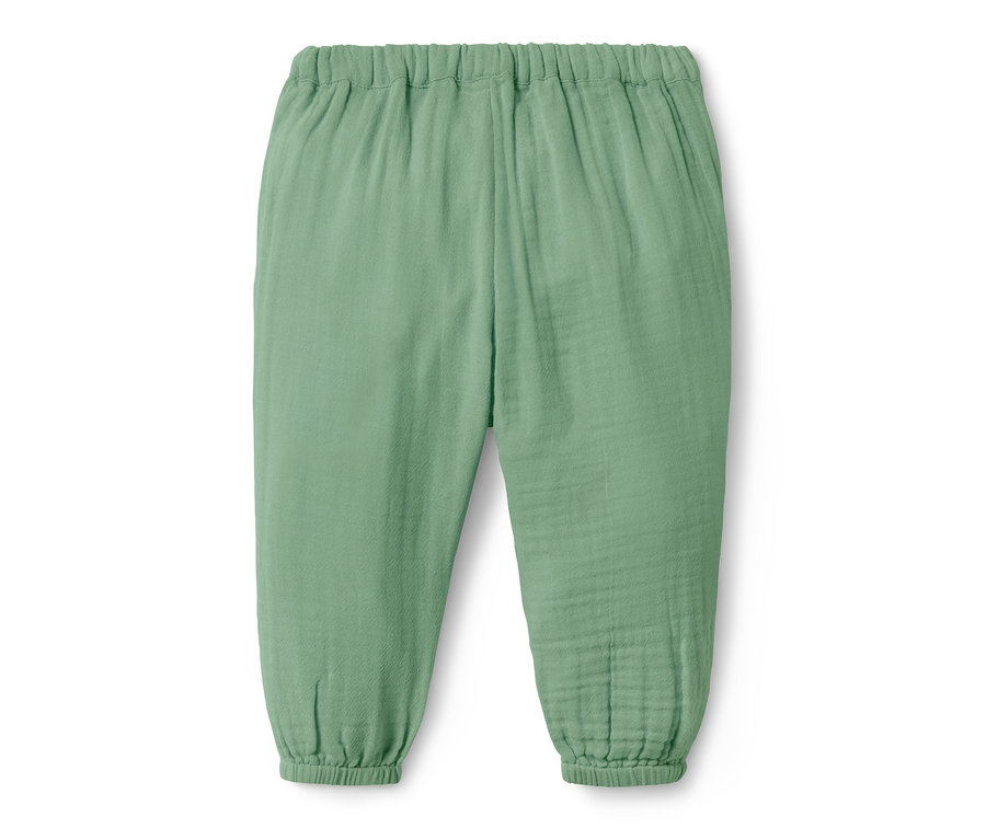 Un pantalon à enfiler pour bébé vert clair sur fond blanc.