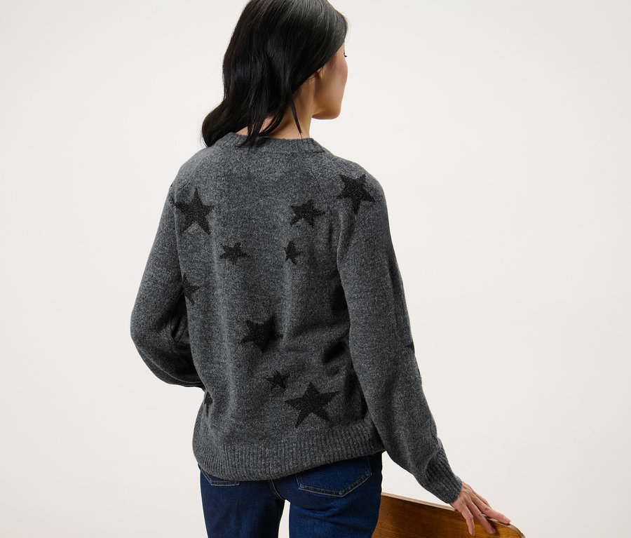 Femme portant un pull en maille avec des étoiles.