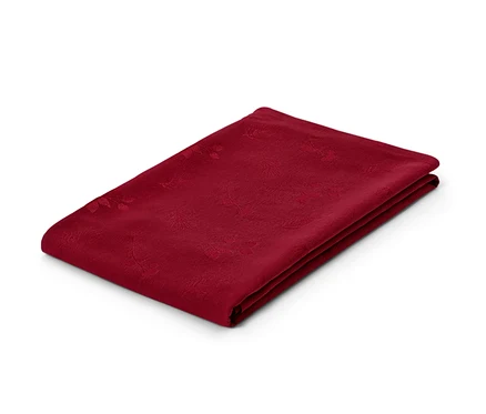 Une nappe jacquard rouge pliée sur un fond blanc.