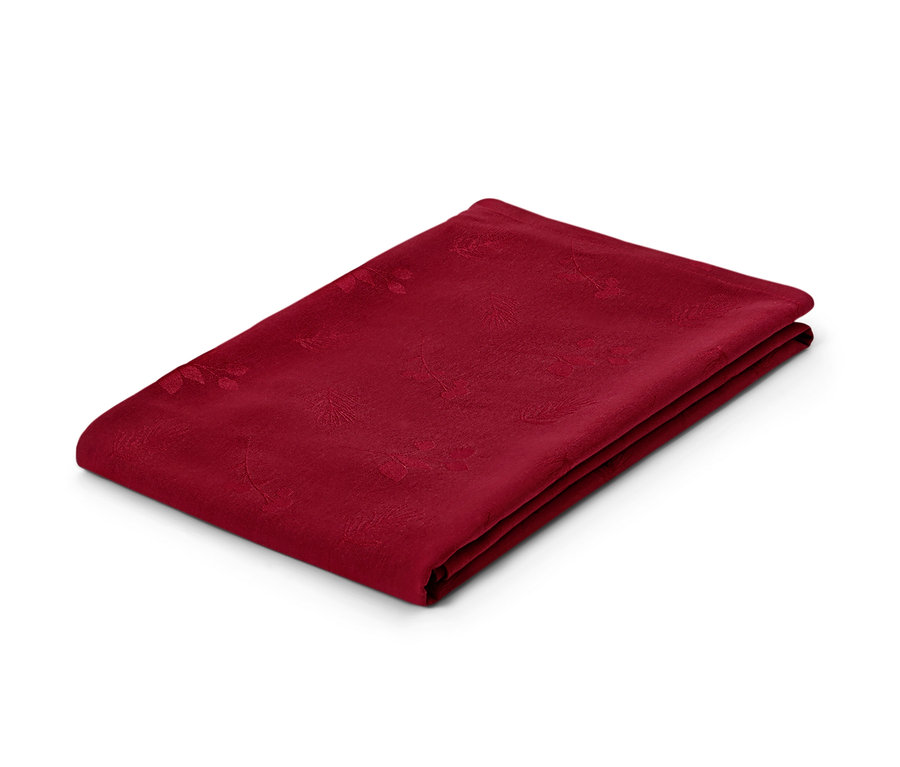Une nappe jacquard rouge pliée sur un fond blanc.