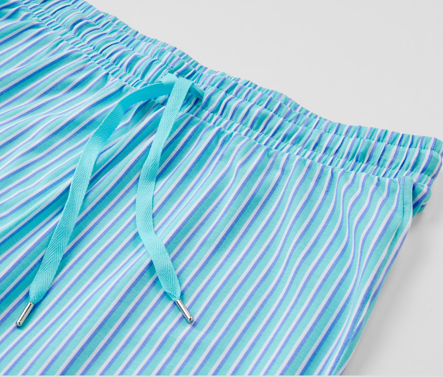 Gros plan d'un pantalon de pyjama rayé bleu et blanc avec un cordon de serrage bleu clair.