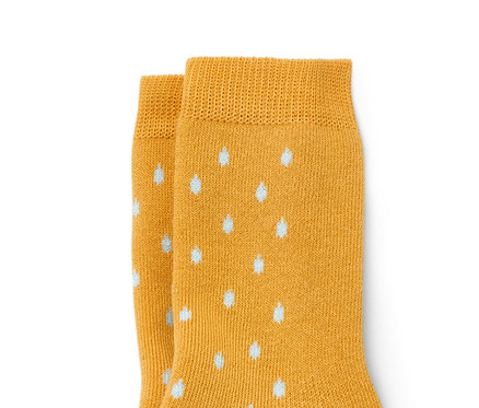 Deux paires de chaussettes anti-dérapantes pour enfant, une paire jaune avec un motif de chien et des points blancs, l'autre verte avec un chien et un parapluie.