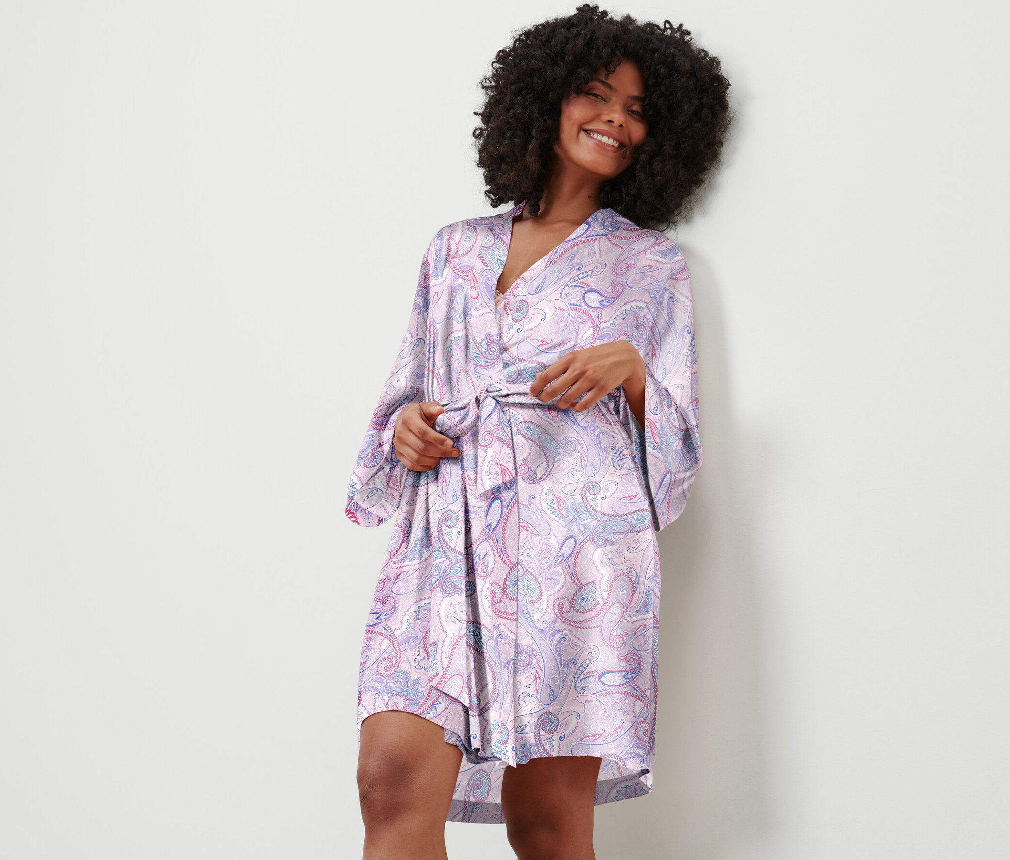Femme attachant une robe de chambre à motif cachemire.