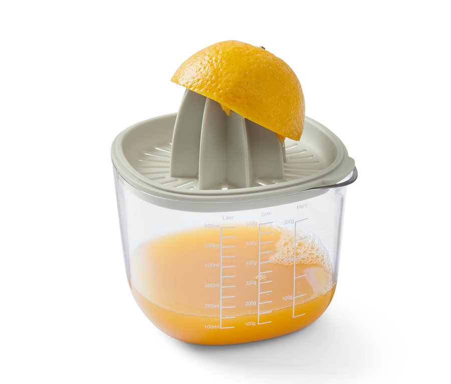 Moitié de citron sur un presse-agrumes de l'ensemble de cuisson et de préparation, sous un récipient transparent avec du jus de citron.