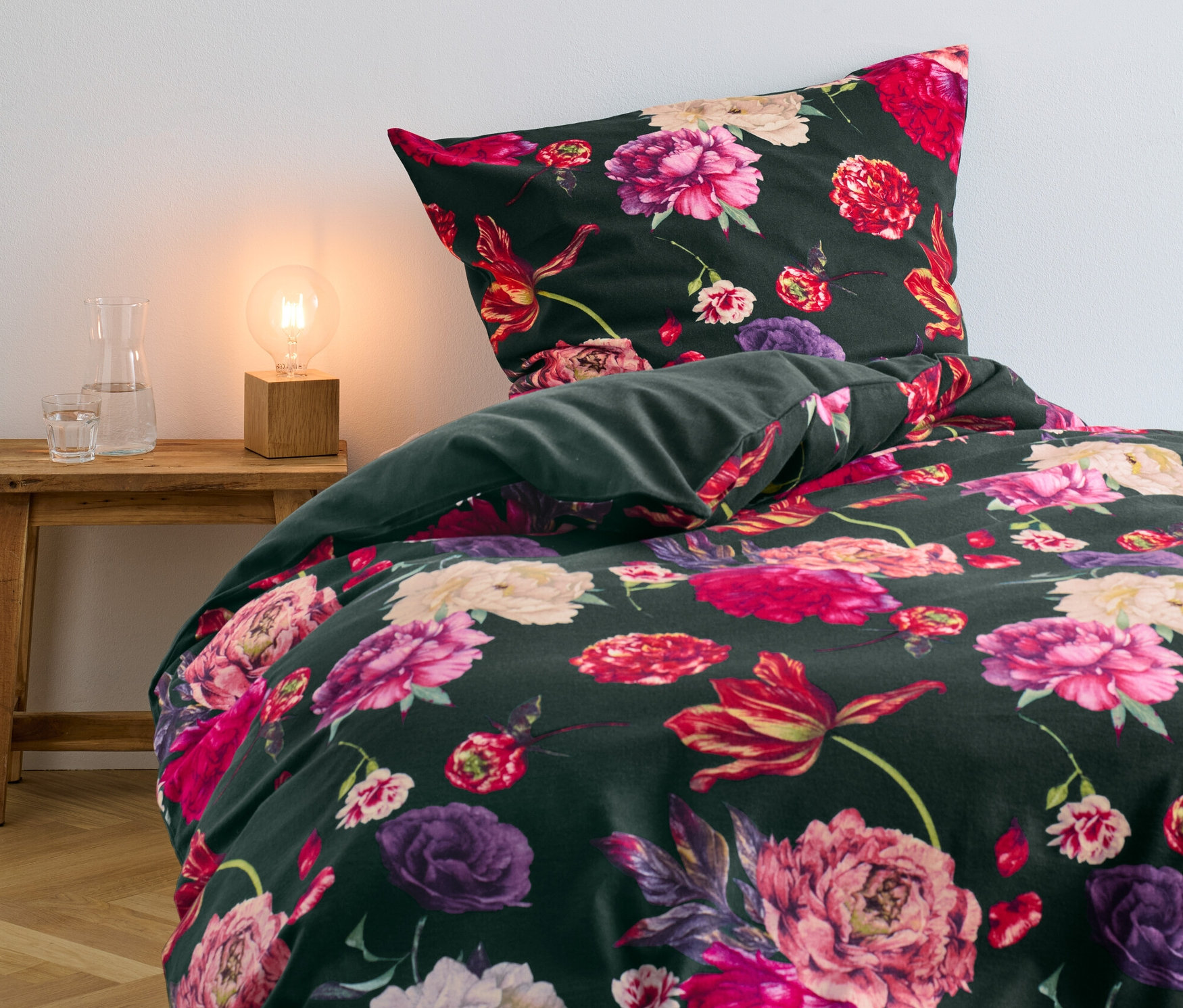 Parure de lit en molleton verte à fleurs sur un lit.