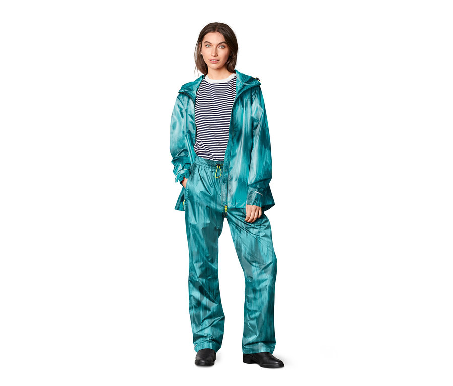 Une femme porte une veste et un Pantalon de pluie, imprimé intégral.