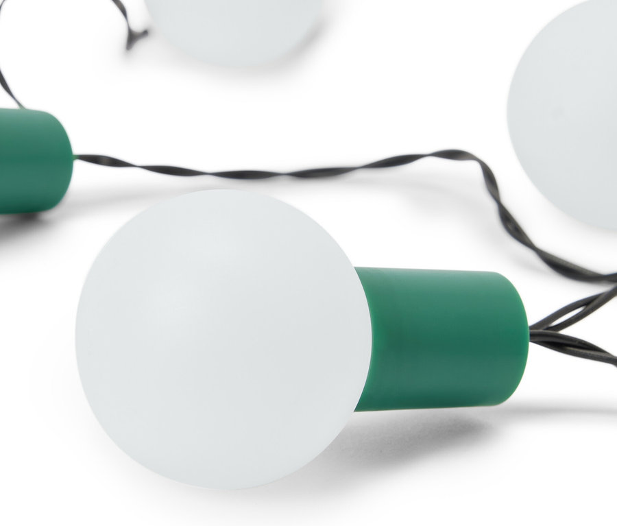 Gros plan d'une guirlande lumineuse à LED avec des ampoules blanches et des douilles vertes sur un fond blanc.