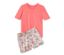 Un pyjama court couleur papaye, composé d'un t-shirt et d'un short à fleurs, est posé l'un sur l'autre.