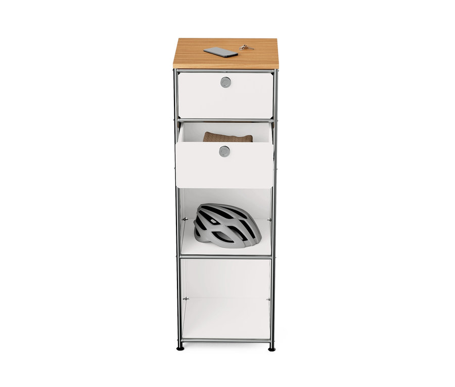 Commode étroite en métal blanc « CN3 » avec plateau en bois et deux tiroirs; un casque de vélo est posé sur l'étagère.