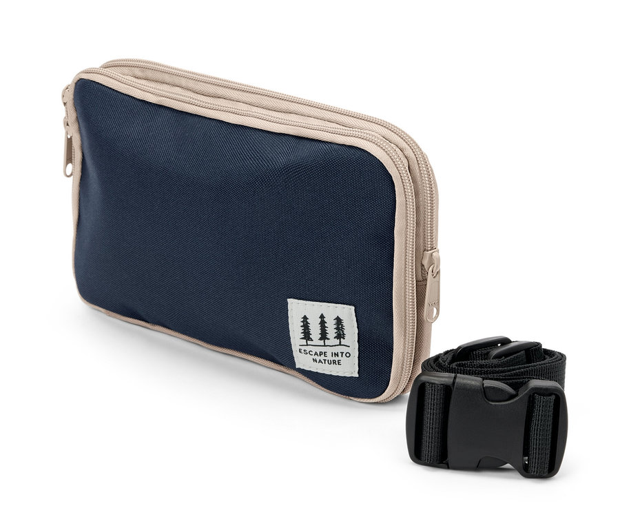 Un sac multifonction bleu marine et beige avec une sangle noire posé sur un fond blanc.