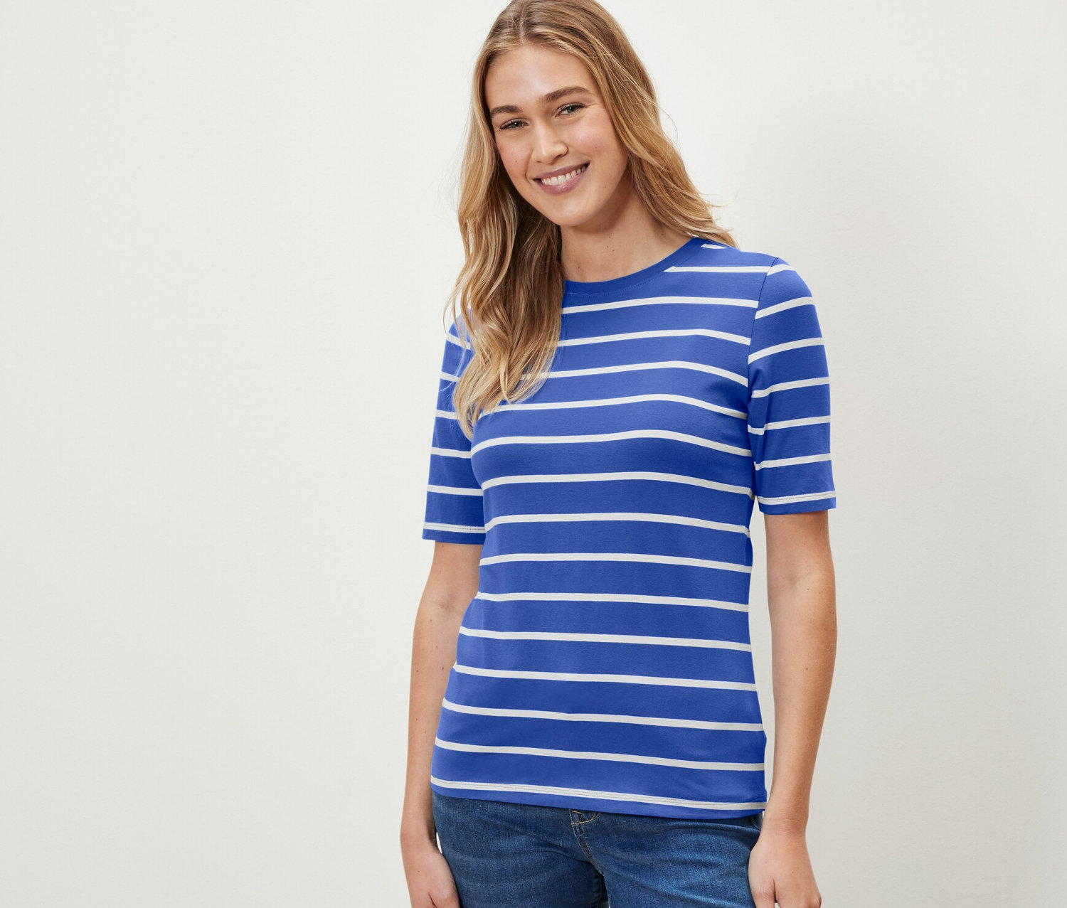 Femme portant un t-shirt à rayures bleues et blanches à manches mi-longues.