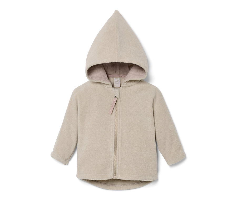 Une veste en polaire beige pour bébé avec fermeture éclair et capuche.