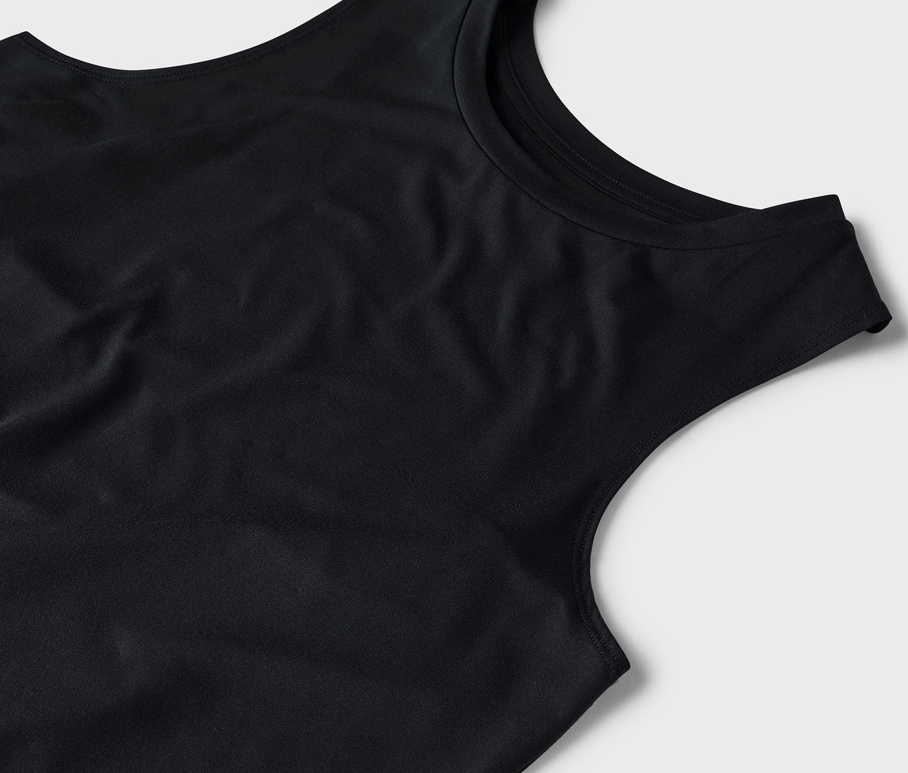 Gros plan d'un débardeur noir sur fond gris.