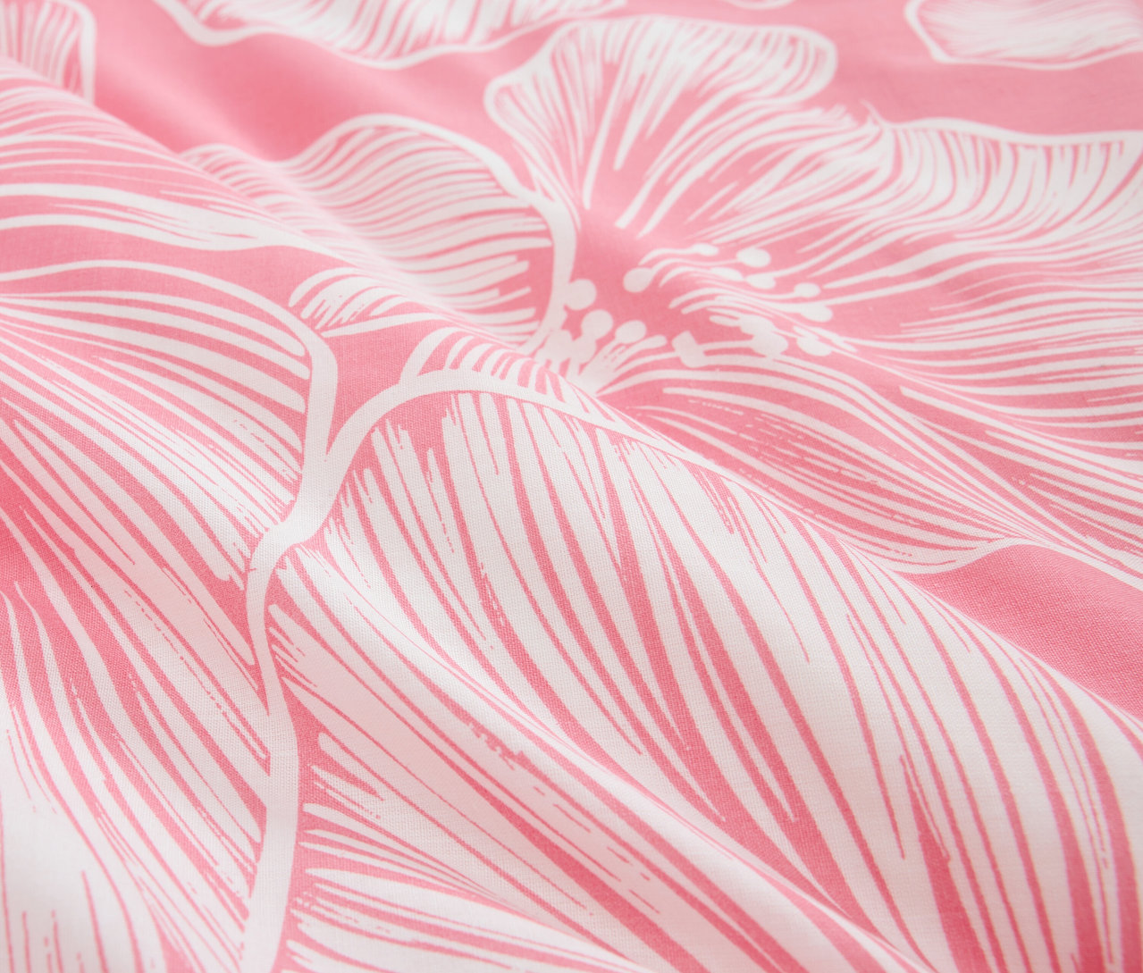 Gros plan d'un tissu rose avec un motif floral blanc.