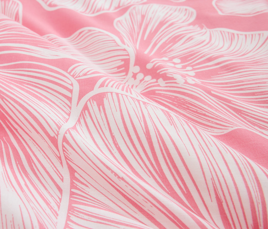 Gros plan d'un tissu rose avec un motif floral blanc.