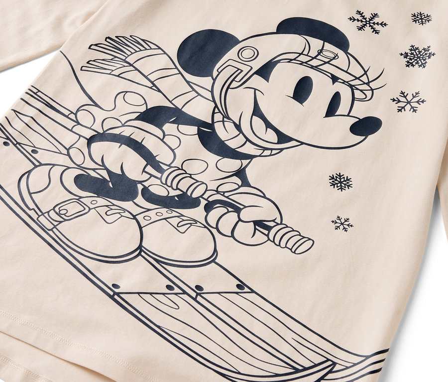 Un personnage de dessin animé, Minnie Mouse, faisant du ski avec un casque, une écharpe et des gants sur un fond beige.