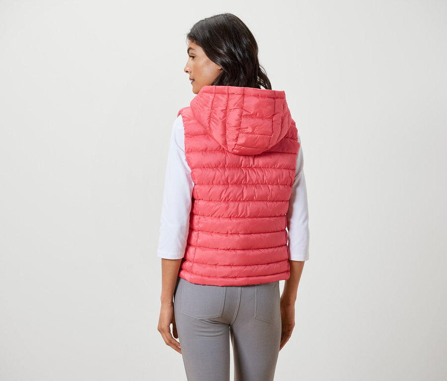 Femme portant un gilet sans manches matelassé à capuche.