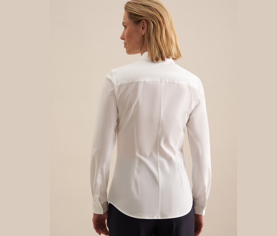 Vue arrière d'une femme blonde portant une chemise Seidensticker Slimfit blanche.