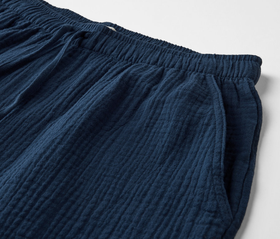 Gros plan sur un short en mousseline bleu marine avec taille élastique et poche.