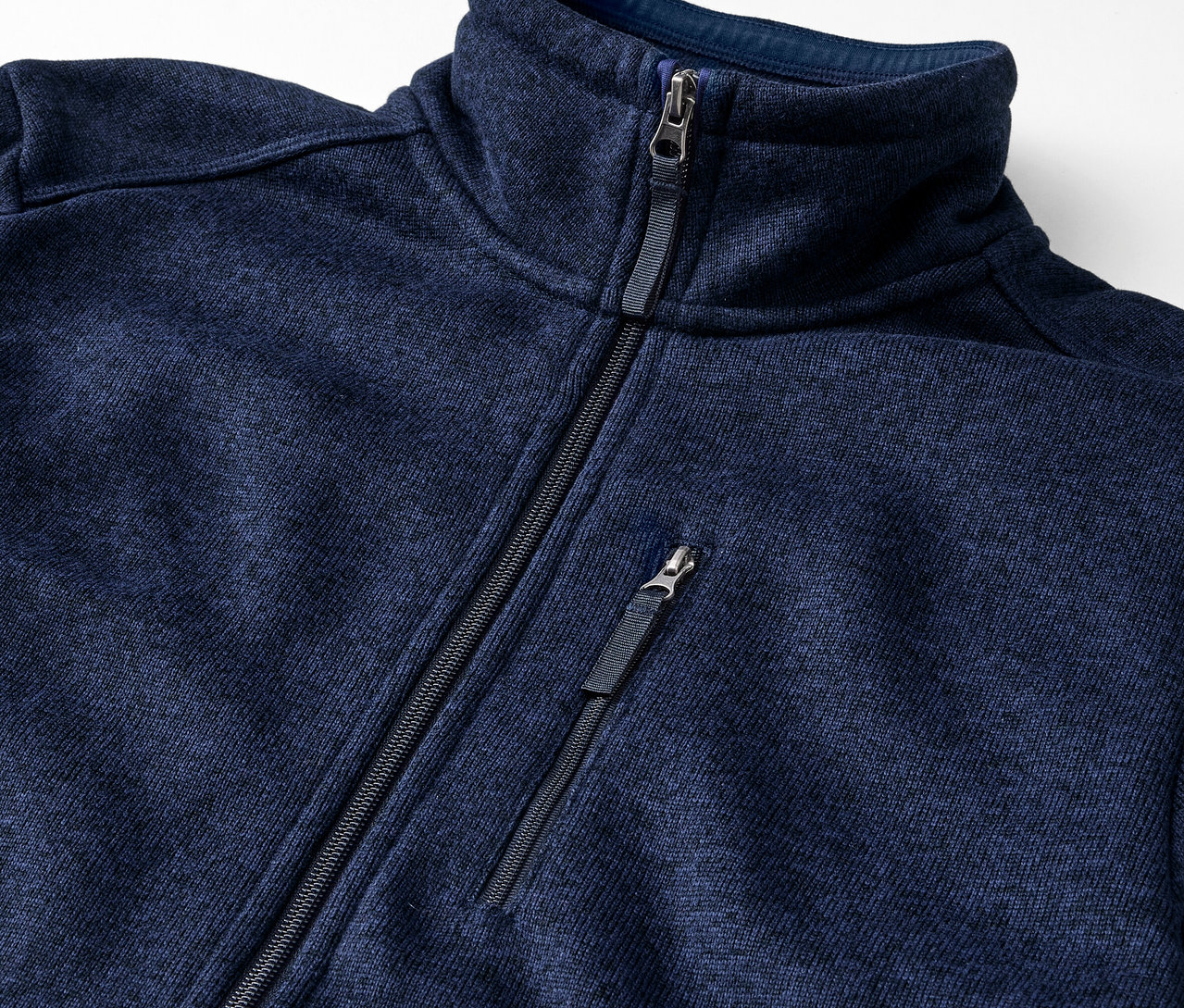 Gros plan sur une veste en polaire tricotée bleu marine avec fermeture éclair.