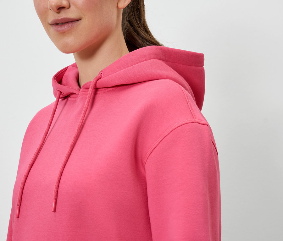 Gros plan sur un sweat à capuche rose pour femme.