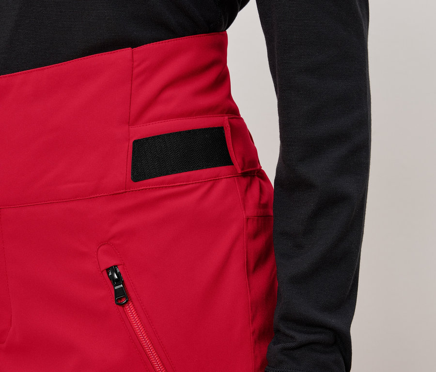 Pantalon rouge taille haute avec trois boutons et un détail noir sur le côté.