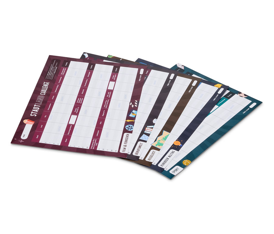 Plusieurs feuilles de papier sont superposées, montrant différentes versions du jeu Stadt Land Fluss.