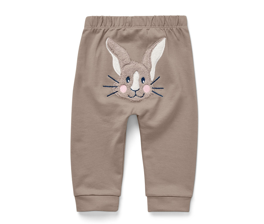 Un pantalon marron pour bébé avec un visage de lapin brodé sur le derrière.