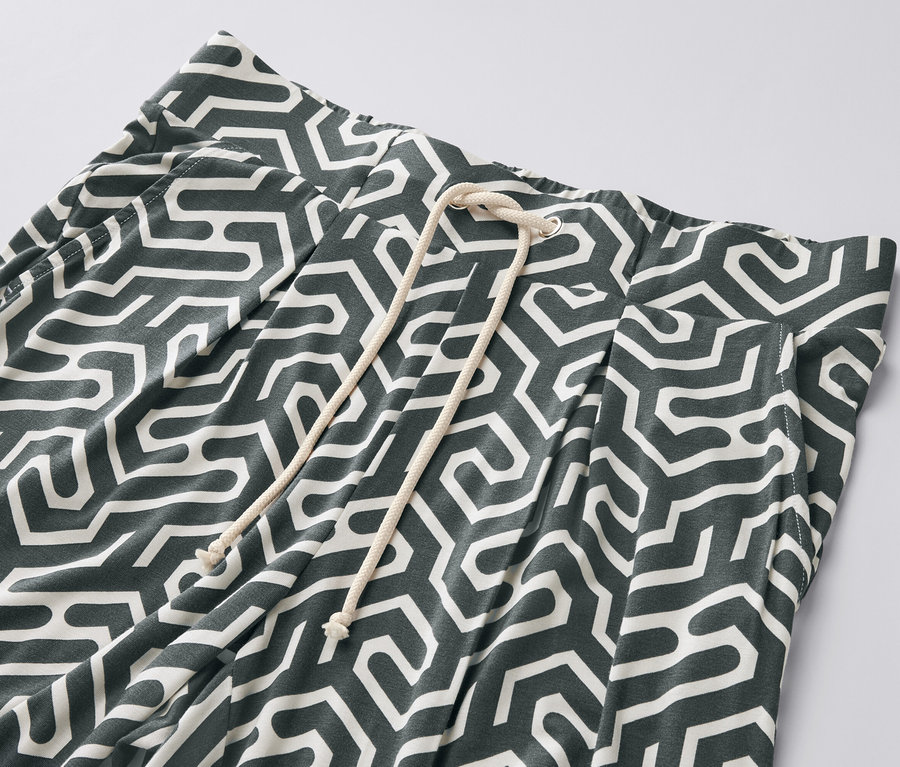 Gros plan sur un pantalon en jersey imprimé vert avec cordon de serrage.