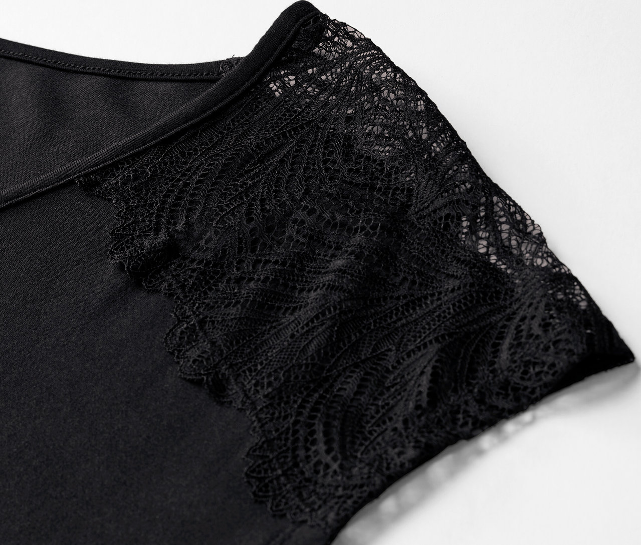 Gros plan sur un pyjama court noir avec des manches en dentelle.