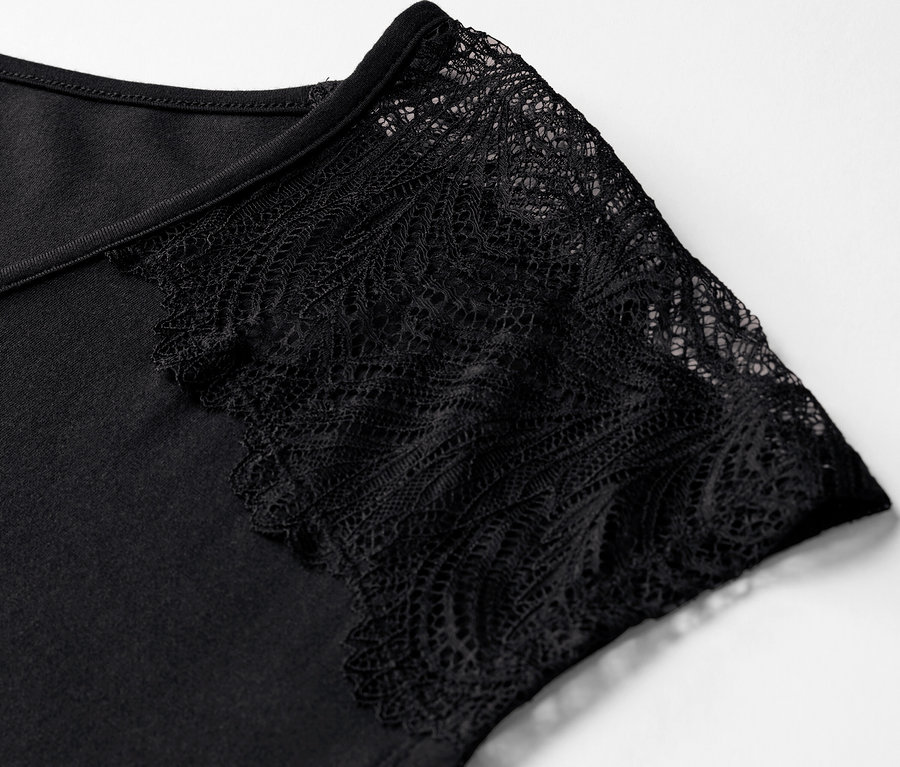 Gros plan sur un pyjama court noir avec des manches en dentelle.