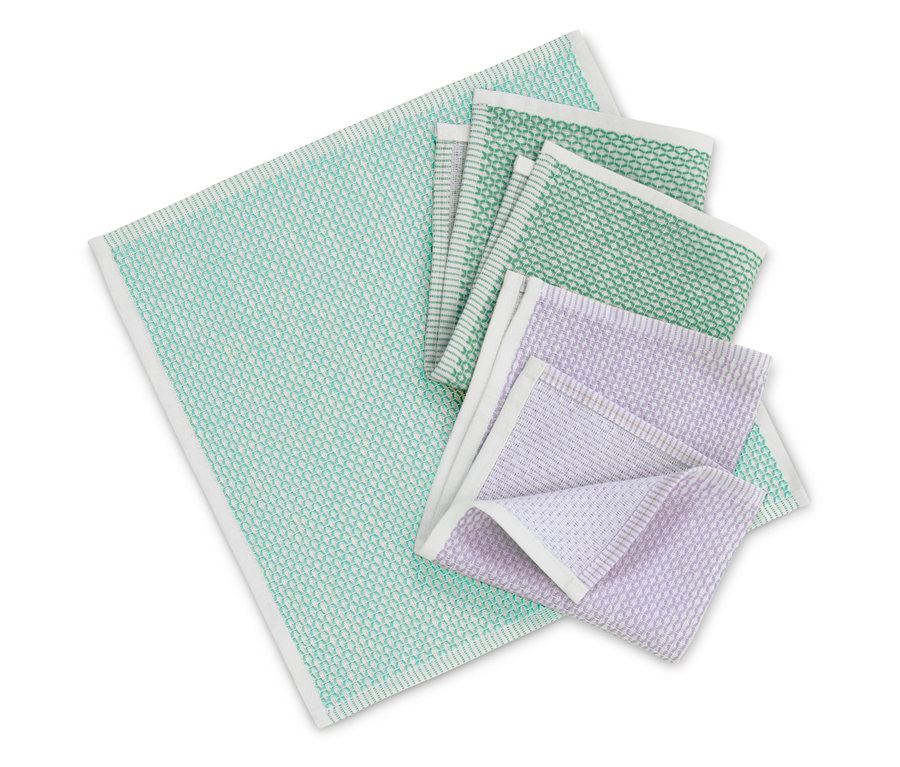 Serviettes de table en tissu de différentes couleurs avec bordure blanche pliées sur un fond blanc.