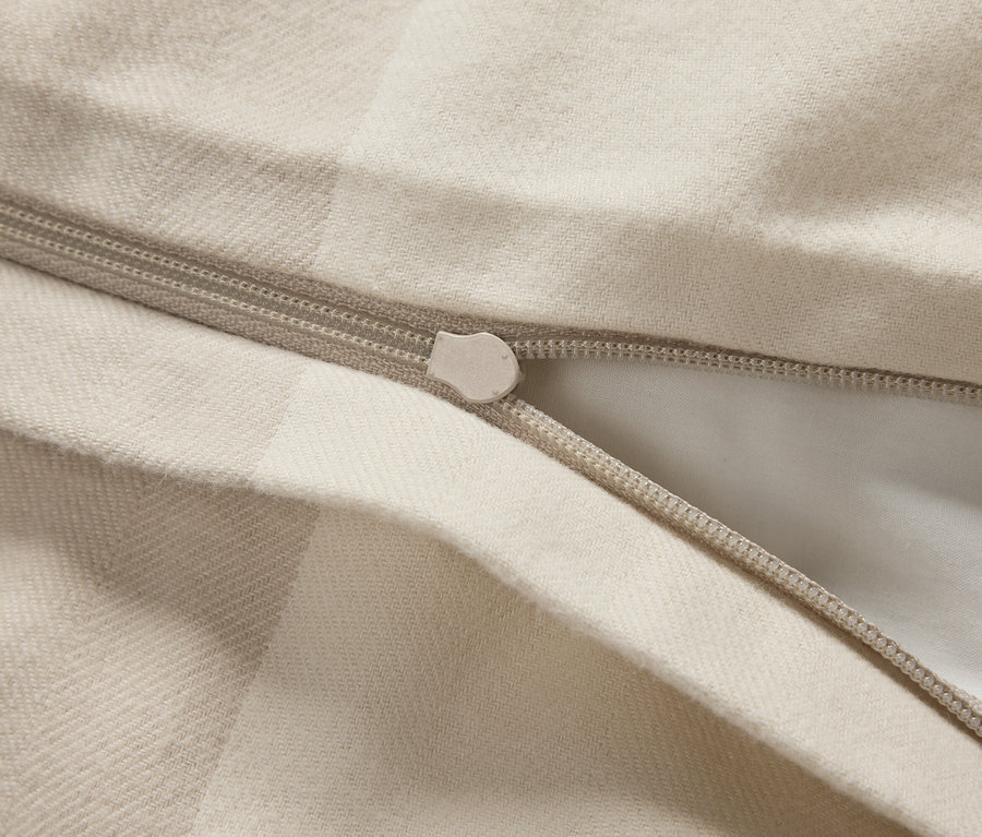 Gros plan d'une housse de couette beige avec une fermeture éclair.