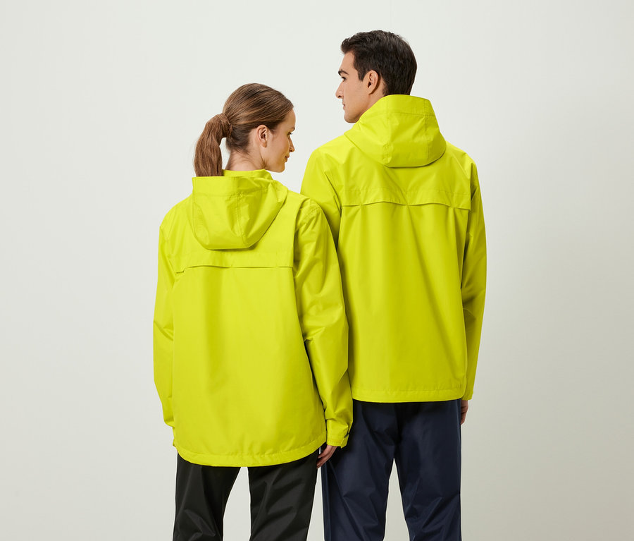 De dos : une femme et un homme portant des vestes de pluie jaunes à capuche.