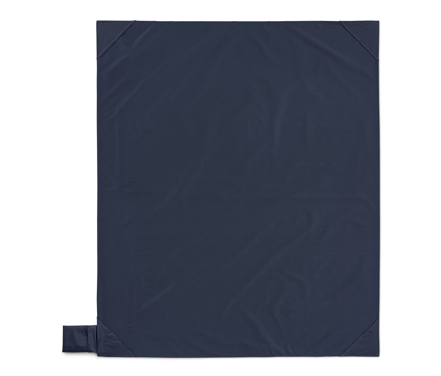Couverture bleu marine avec un petit sac rectangulaire dans le coin inférieur gauche, isolée sur blanc.