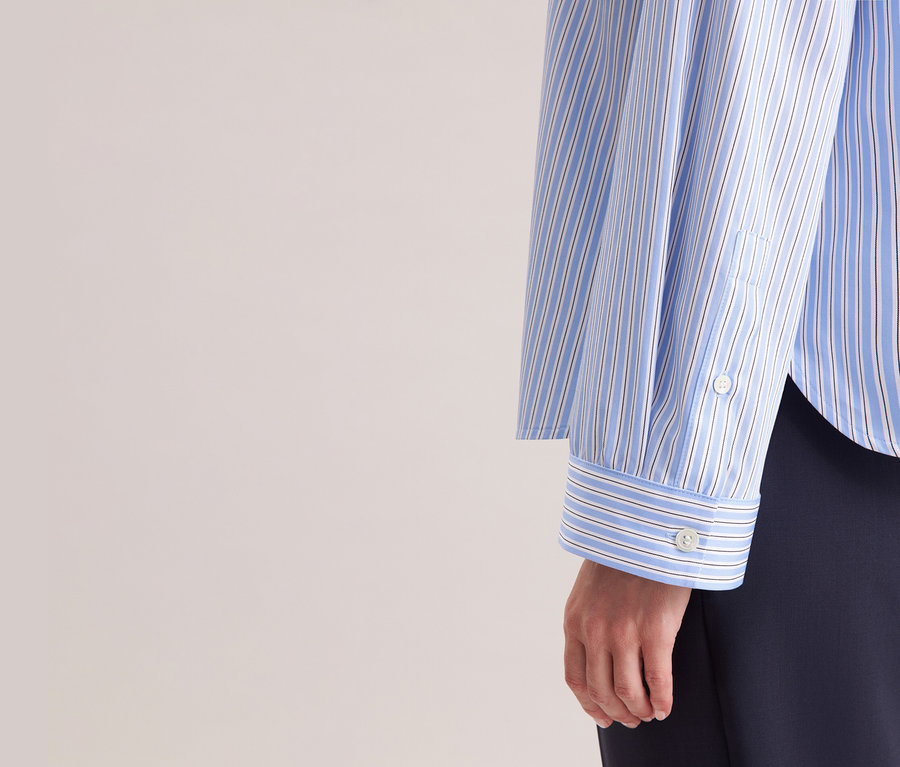 Femme portant une chemise oversize Seidensticker bleu et blanc à rayures.