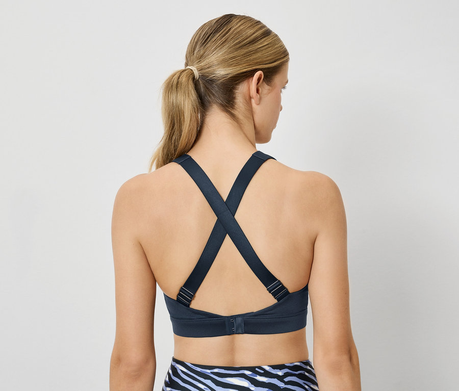 Une femme portant un soutien-gorge de sport avec des bretelles croisées dans le dos.