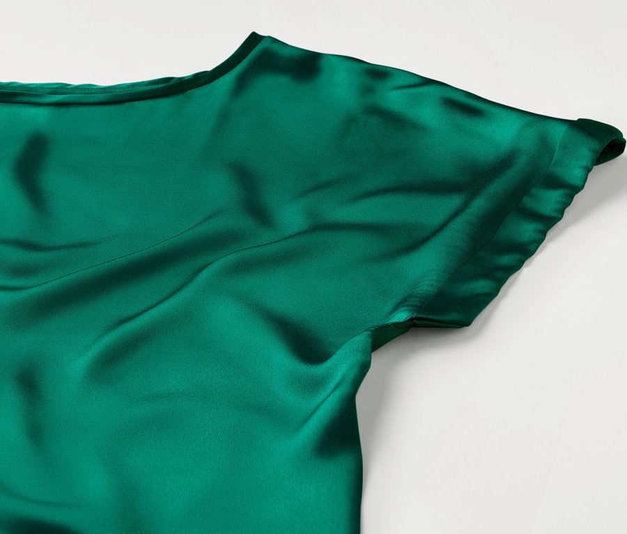 Gros plan sur une blouse bimatière turquoise.