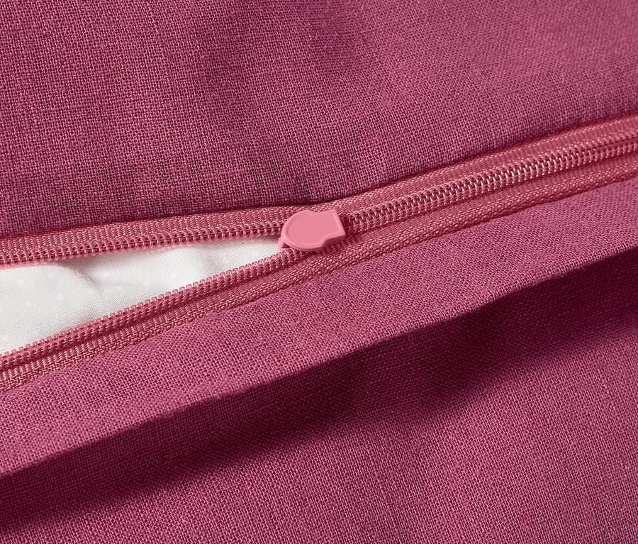Gros plan d'une parure de lit en tissu métis, grande taille, avec une fermeture éclair rose.