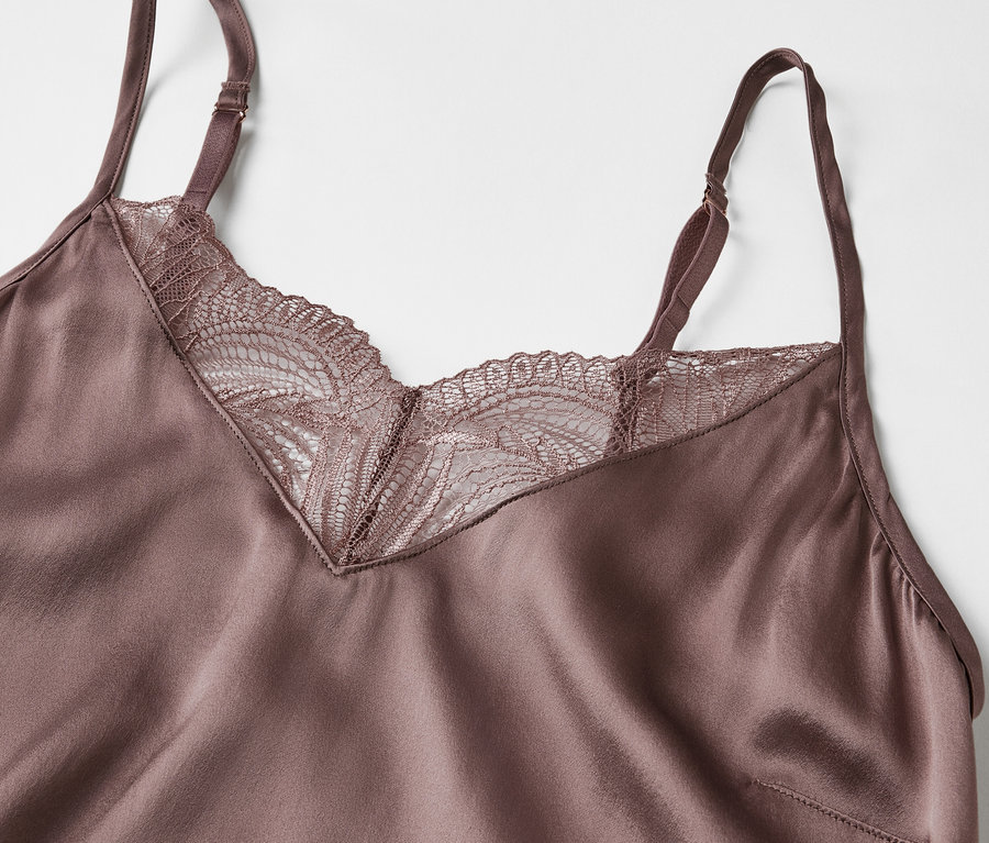 Vue détaillée d'un débardeur en satin violet avec de la dentelle sur l'encolure.