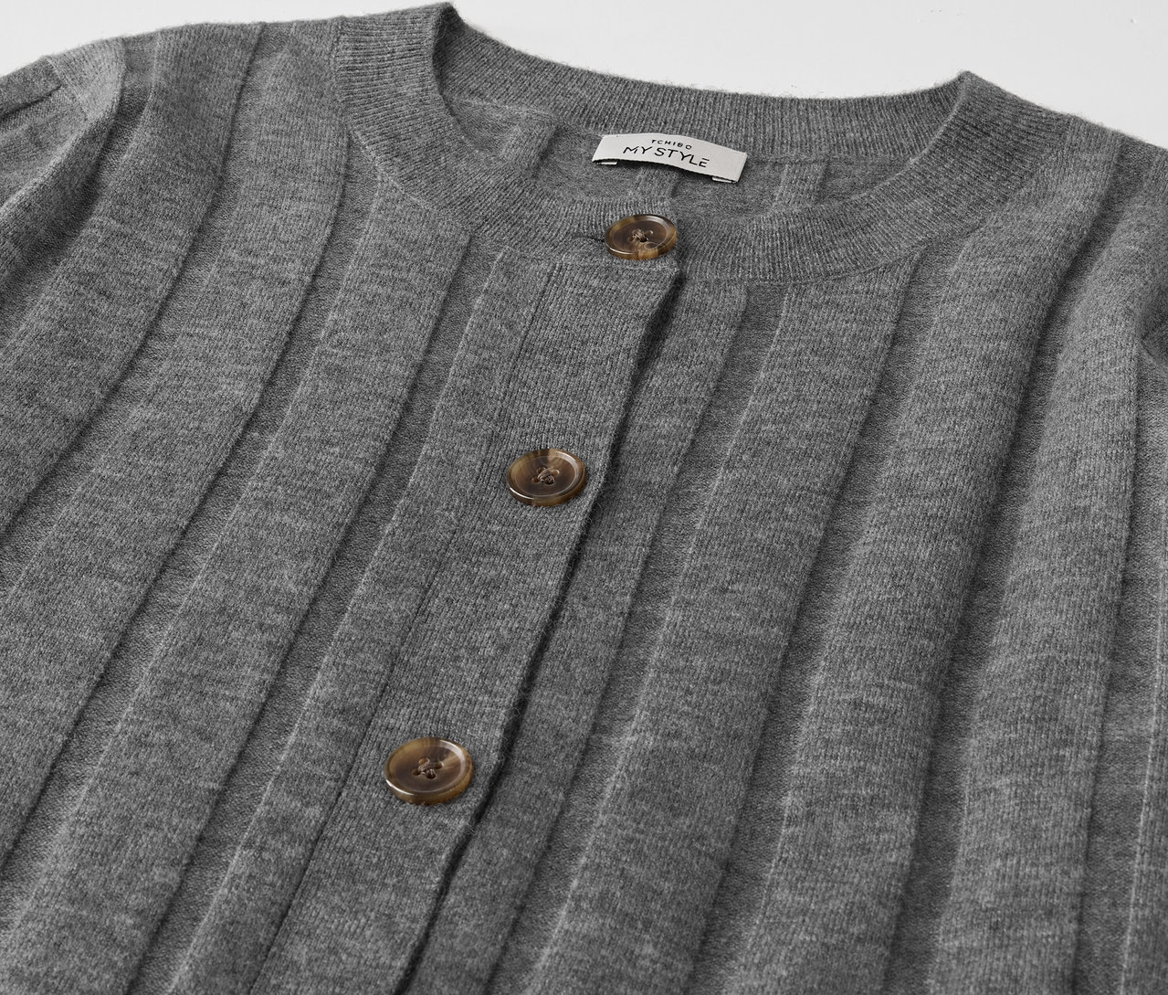 Gros plan sur un cardigan gris boutonné.